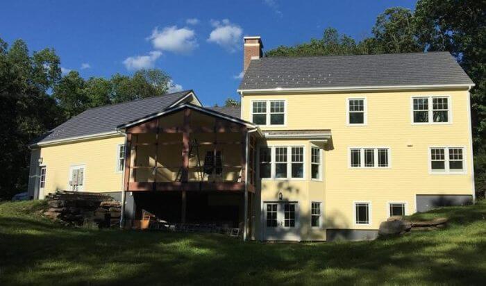 A platinum metal roof on a large yellow house with a screened in back porch in MA, CT, NH, or RI