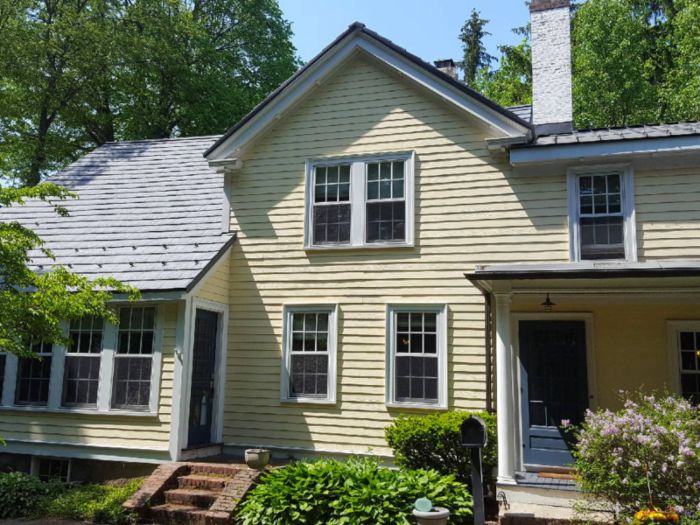 A metal roof on a yellow house installed by Classic Metal Roofs serving MA, CT, NH, and RI