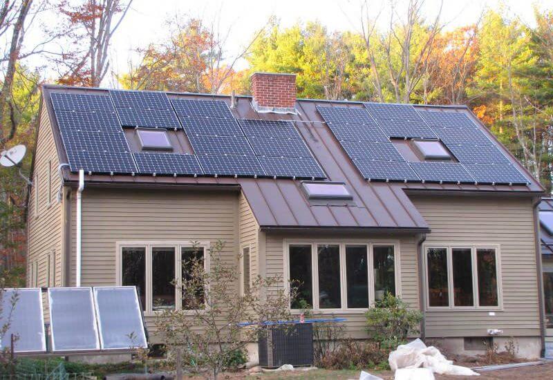 solar panels on the metal roof of a brown house in MA, CT, NH, or RI