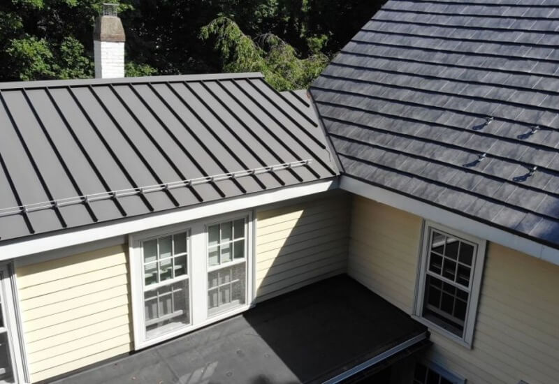 two types of metal roofs intersect for a home in MA, CT, RI, or NH