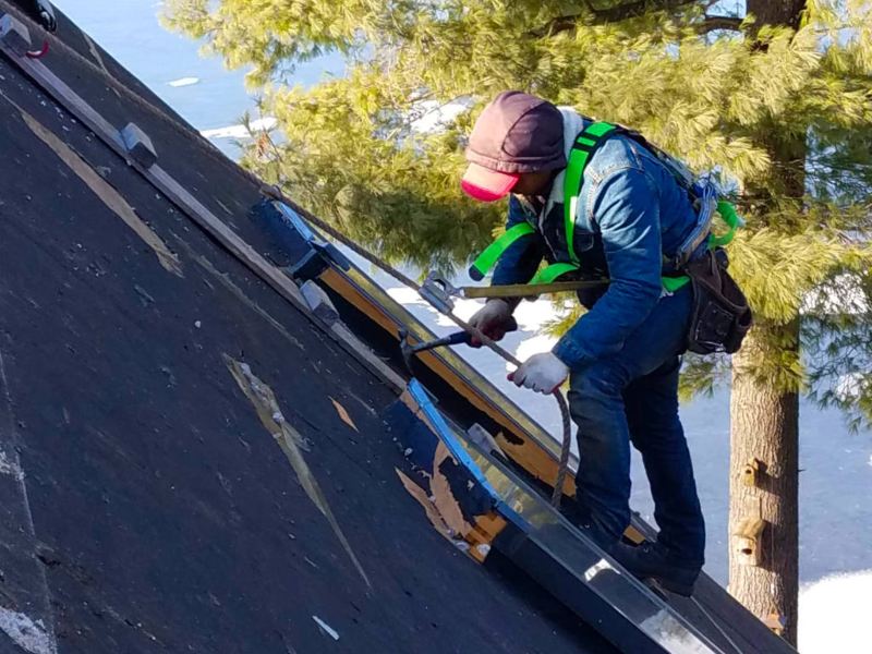 An OSHA-certified roofing contractor installing a new metal roof in MA, CT, NH or RI