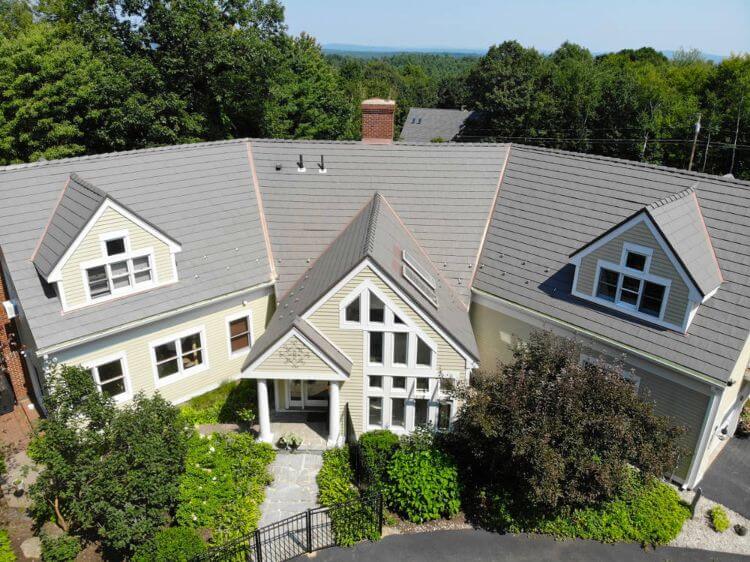 Grey metal roof on a light yellow house in MA, CT, NH, or RI