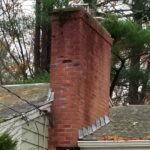 old asphalt roof with full gutters and dilapidated brick chimney