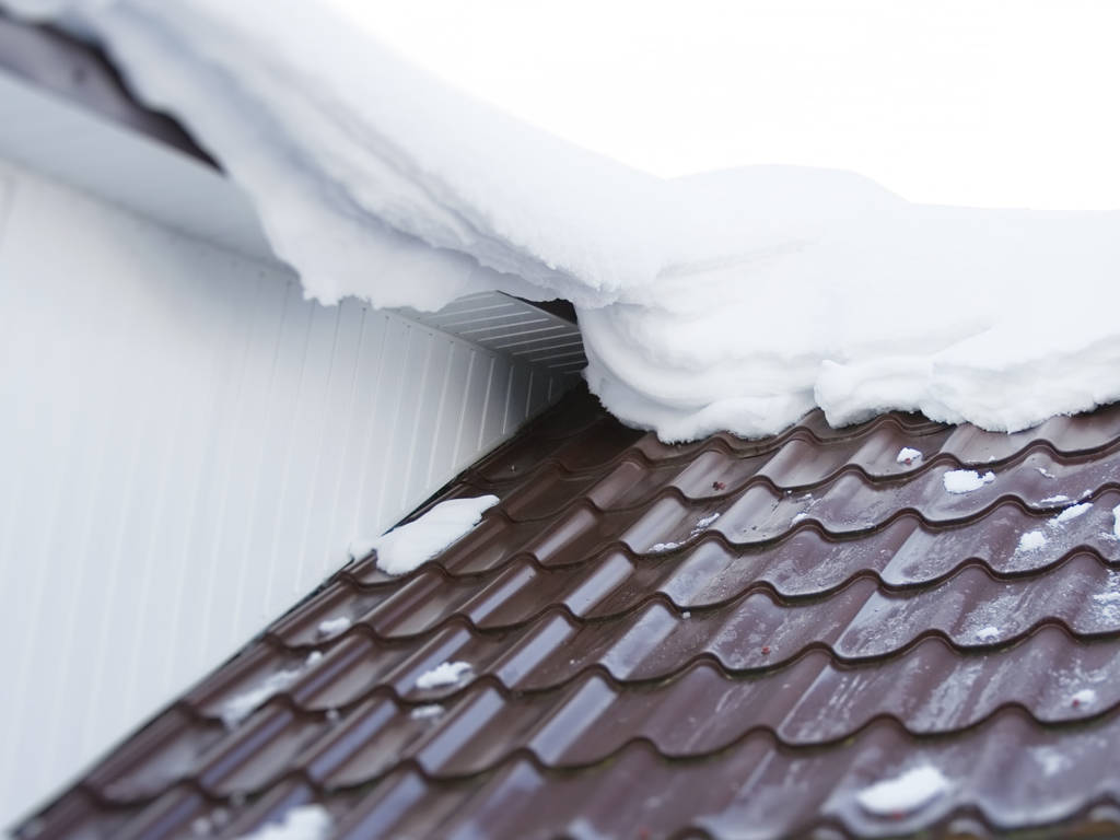 A metal roof with snow on it in Stow, MA