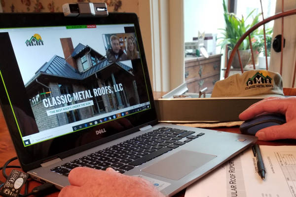 A man seeing a metal roof website on a laptop in MA CT NH RI