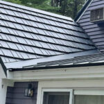 A roofing contractor in MA used black metal roof shingles on a grey house