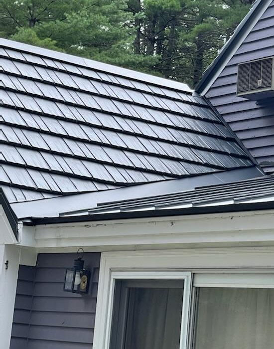 A roofing contractor in MA used black metal roof shingles on a grey house