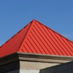 A standing seam pyramid roof in red metal on a home in southern New England