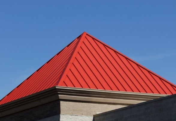 A standing seam pyramid roof in red metal on a home in southern New England