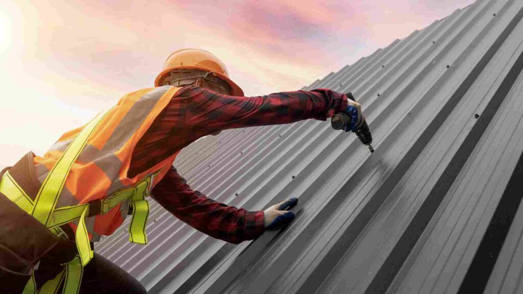 A man in an orange safety vest is diligently working on a metal roof, ensuring safety and precision in his task.